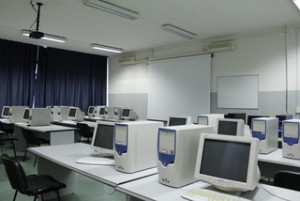 laboratorio d'informatica con pc bianchi, videoprioettore, aria condizionate, finestre con tende coprenti