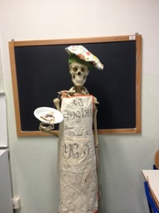 Il manichino di uno scheletro vestito come uno chef con in mano un piatto con una crepe alla Nutella simbolo del laboratorio di cucina.