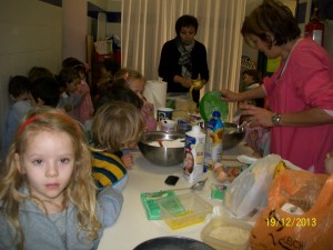 Bambini he preparano la torta di mele con l'insegnante durante il laboratorio di cucina
