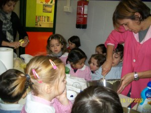 Bambini che preparano un dolce con l'insegnante durante il laboratorio di cucina